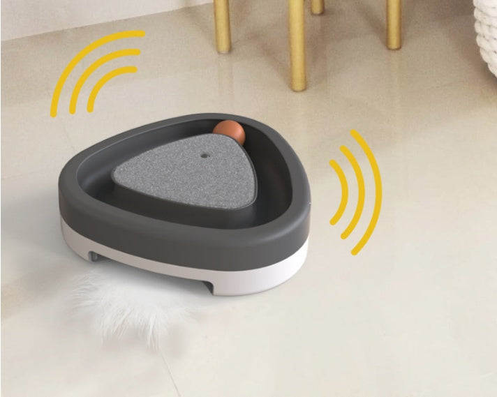 Interactive cat toy with feather and ball on floor, triangle-shaped design